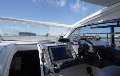 Princess V39 cockpit helm with twin displays, Volvo Penta controls, large windscreen and opening roof.