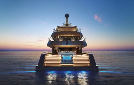 Aft view of Feadship Project Freedom at dusk, aft of yacht lit with blue underwater spots and illuminated pool