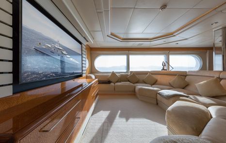 Blohm+Voss Superyacht Zeus upper deck salon with curved white seating and large mounted TV