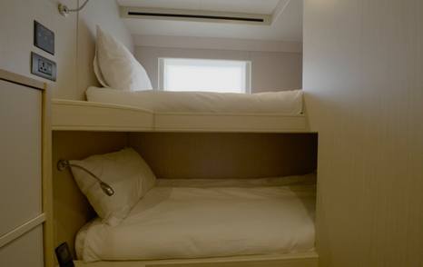 Crew bunk cabin aboard the Gulf Craft Majesty 145 with over-under berths and natural light