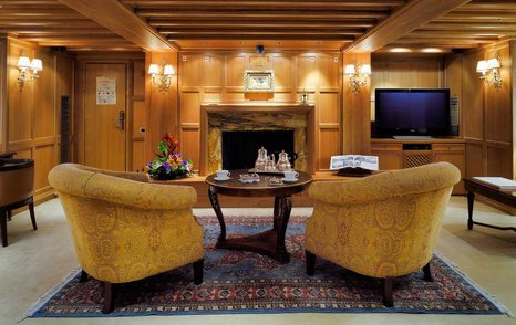 Superyacht Christina O lounge area with brown chairs and wooden coffee table