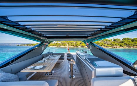 Overview of the flybridge onboard Sunseeker 88 Yacht, seating to port with wetbar and stools along starboard side.