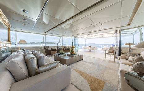 Blohm+Voss Superyacht Zeus salon with grey sofa and glass doors 