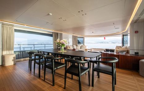 Superyacht Tosun main saloon dining area with black dining table and chairs