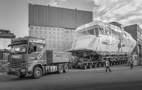 Side view of Numarine 26XP sitting on a trailer awaiting transit, surrounded by shipyard buildings