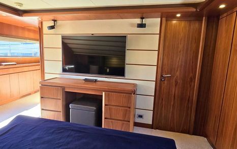 Bleu Blanc main cabin with TV unit, storage, and wood panelling