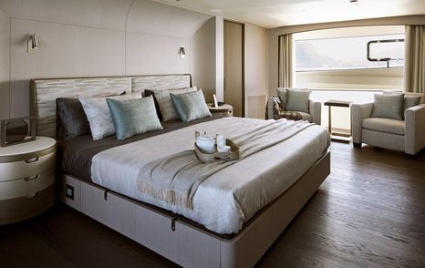 Benetti Diamond 145 INK superyacht bedroom with double bed and two comfortable arm chairs in front of window