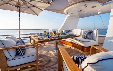 Tables and sofas on sun deck of Trinity superyacht White Star