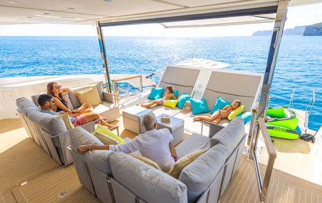 Family lounging in comfortable chairs on deck of Sunseeker 90 Ocean