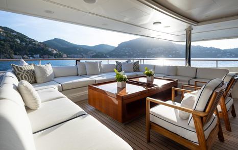 Superyacht Vision's aft U-shaped seating area with cream furnishings