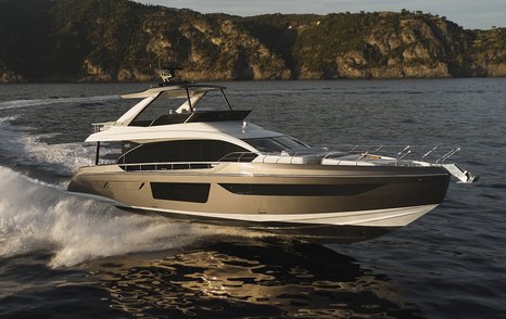 Azimut 68 Fly underway, surrounded by sea with cliffs in background.