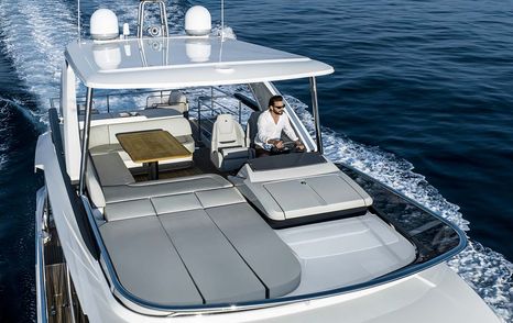 Next-Gen Absolute 52 FLY motor yacht flybridge with grey sunpads while under way 