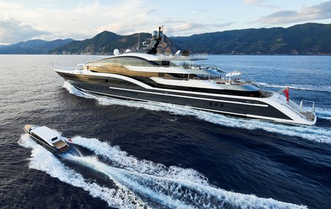 Oceanco yacht DAR running shot alongside custom yacht tender Seen from port side making way at reasonable speed in calm water, with land in background