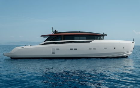 A starboard-side view of the Sanlorenzo SP92, with a black hardtop and a white hull, anchored in a blue sea