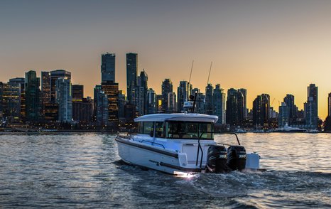 Tender boat on water with city scape in background at twilight