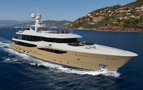 Superyacht AMIGOS making way through a dark blue sea, showcasing her unique sand-colored exterior