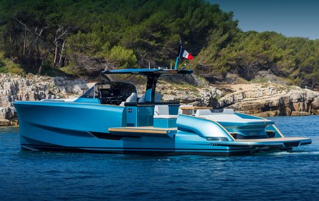 Solaris 44 Open on anchor in picturesque location in calm sea, side wings open to extend the aft deck by the water, stunning blue hull colour, bright day