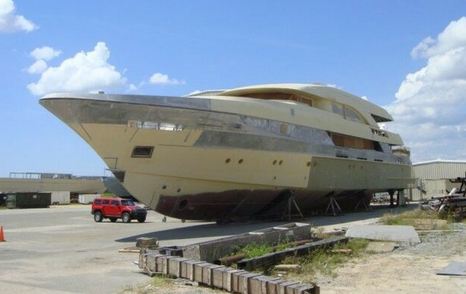 Forward view overlooking the bow of incomplete Trinity T056 hull, sat on tarmac after auction.