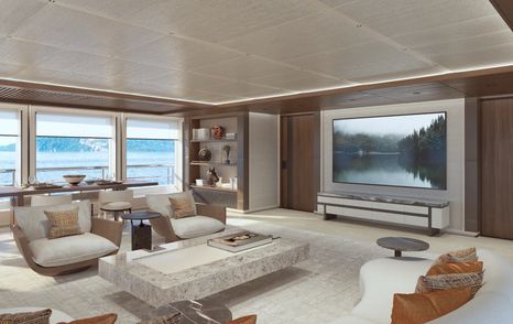 Overview of Owners lounge on board Amels 80. Seating arranged around wall mounted flat screen TV. Large windows around exterior walls.  