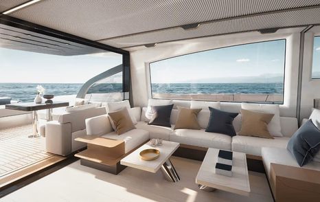 Main salon onboard the Azimut S7 Mk2, U shaped white sofa with scatter cushions surrounds two low coffee tables, with long stretch of glazing in background. Aft dining area visible to port side.