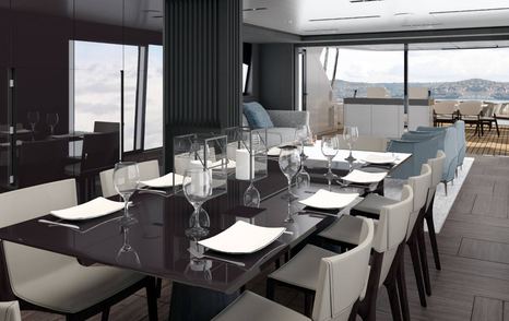 Dining area onboard Pershing GTX116. Long black table surrounded by chairs, aft deck visible in background.