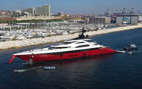 Superyacht LEONA on water after launch, surrounded by tugs and tenders.