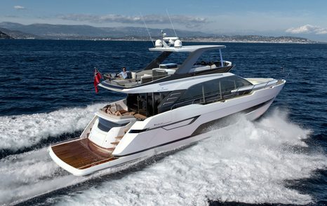 Fairline Squadron 68 running shot, starboard quarter deck and side profile, in smooth sea, on bright day, land in background