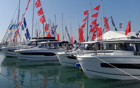 Yachts berthed at the Southampton International Boat Show with flags in the background