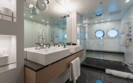 Ensuite facility in master cabin onboard superyacht WANDERLUST. His and hers sinks in foreground with wet room in background 