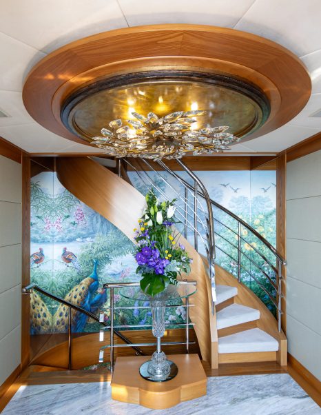 Superyacht Vibrance interior spiral staircase with peacock wallpaper 