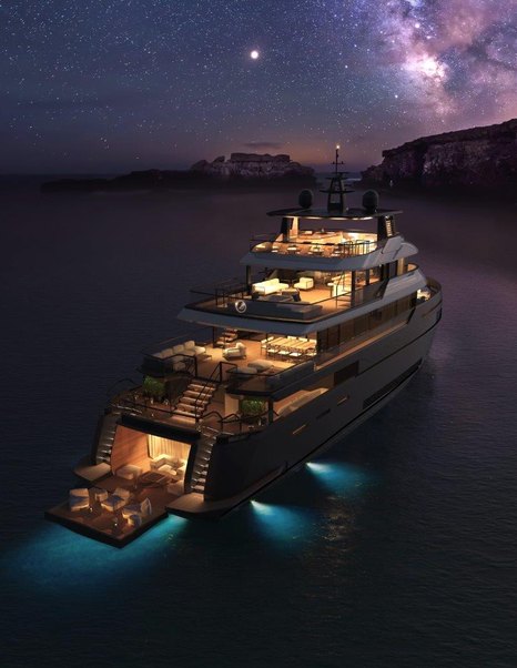 Benetti B.Yond explorer yacht traveling at night with decks light up and lights from boat shining on water