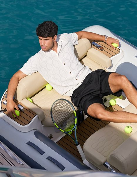 Carlos Alcarez surrounded by tennis balls on aft of boat 