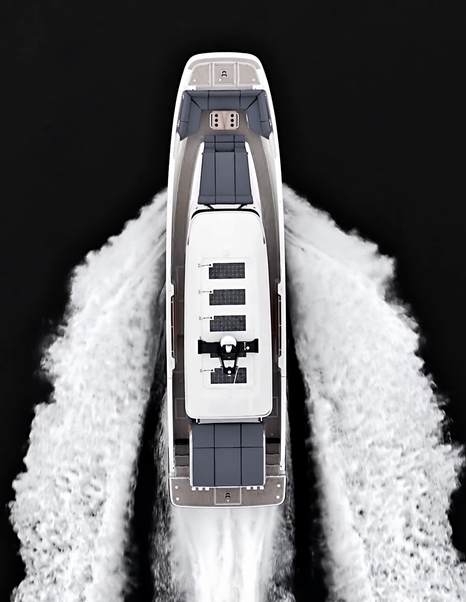 Top-down drone view of the AIATA Sunfinder 50 at speed, revealing the foredeck sunpad, wheelhouse roof and wide wake trailing astern.