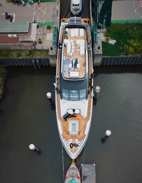 Aerial view of Van der Valk 40m Superyacht Shine leaving Dutch canals following tugboat 