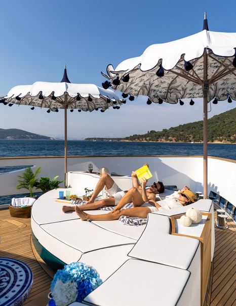 Couple reading on Sirena 118 Superyacht IKIGAI foredeck