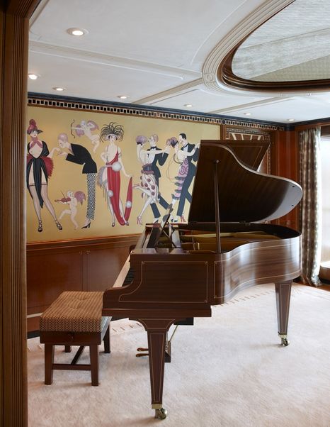 Lady Christine’s piano bar featuring a grand piano, wood-paneled walls, and an Art Deco mural depicting elegant figures in motion.
