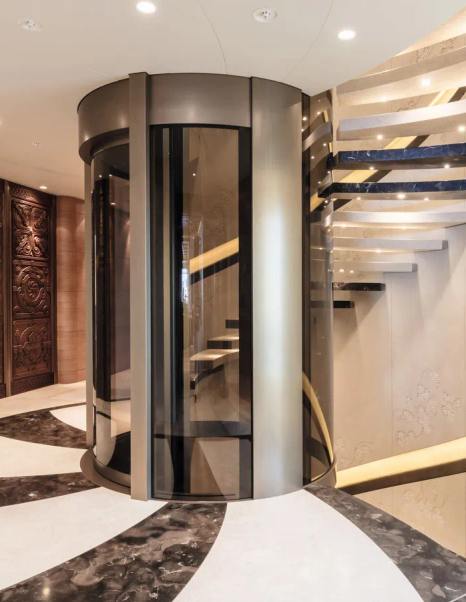 Superyacht Here Comes The Sun interior spiral staircase and glass encased elevator
