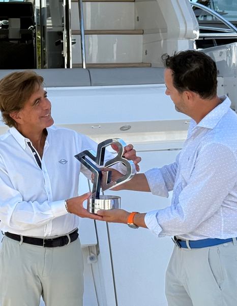 Kevin Bodington handing over the YachtBuyer Hall of Fame Trophy for the Sunseeker Manhattan 55 at the Cannes Yachting Festival
