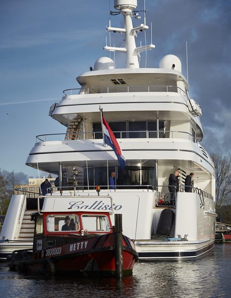 Aft view of Feadship CALLISTO superyacht, Feadship team members onboard looking out on multiple decks.