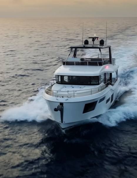 Beneteau Grand Trawler 63 bow view underway showing full-displacement hull and enclosed wheelhouse