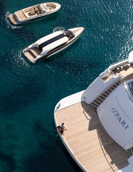 Superyacht O'PARI with couple on swim platform and tenders at side