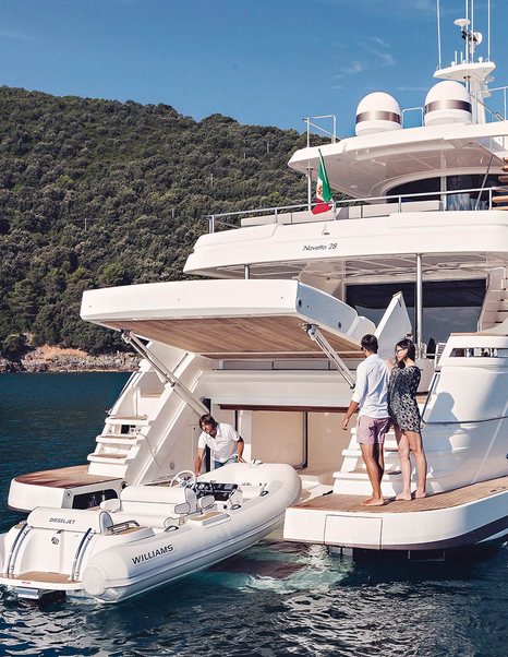 Tender at back of large superyacht with three people watching