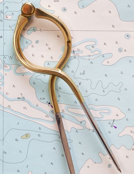 close up of dividers on nautical chart note depth contours