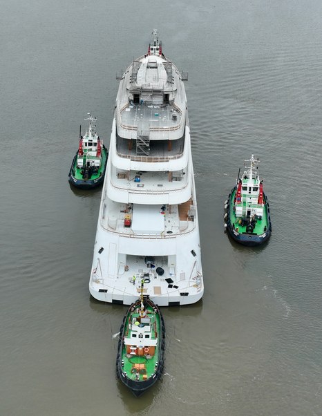 Aerial view of Superyacht Project Defy surrounded by tugboats