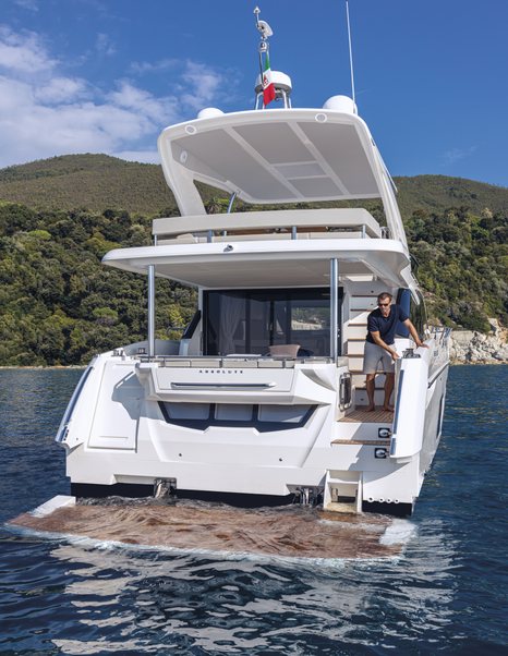 Aft view of Absolute 50Fly, swim platform submerged and guest overlooking from main deck aft