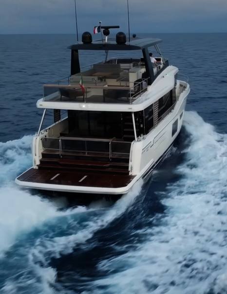 Beneteau Grand Trawler 63 stern view underway highlighting full-beam aft deck and wide swim platform