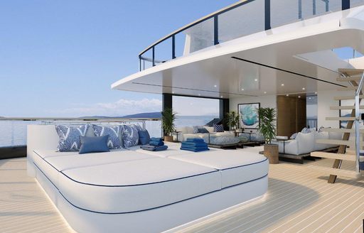 Veranda on sun deck of Benetti B.Yond explorer yacht. Large sunlounger on wooden deck and clear sky in the background