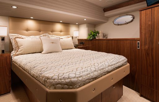 Guest cabin onboard Viking 75 MY, central berth with small porthole window and storage.