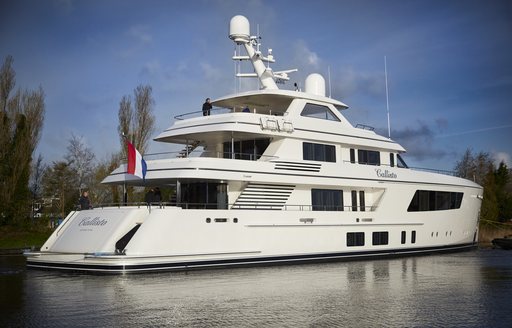 Starboard view of Feadship CALLISTO on water, surrounded by trees.