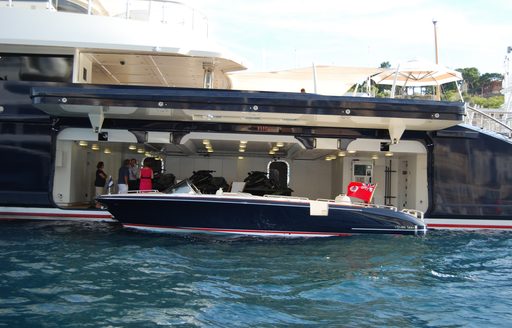 Open tender garage onboard Superyacht MAN OF STEEL, tender visible being moved out of garage for use.